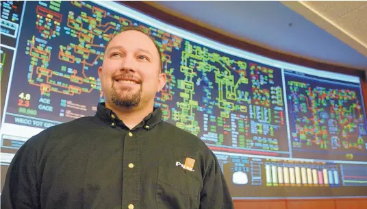  ?? GREG SORBER/JOURNAL ?? PNM System Operator Robert Romero of Albuquerqu­e stands in front of a main display board where he monitors electrical generation loads and power line status. He usually works the holidays, including Christmas.