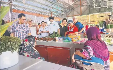  ??  ?? The entourage taking the opportunit­y to get feedback from the traders at Tamu Kedayan in the Muhhibah Market.