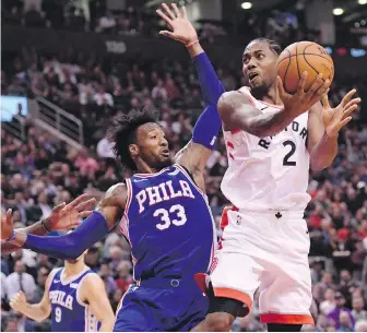  ?? NATHAN DENETTE, THE CANADIAN PRESS ?? Raptors forward Kawhi Leonard looks to go to the hoop as 76ers forward Robert Covington moves in during the first half in Toronto on Tuesday.
