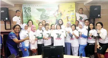  ??  ?? Christina (sixth right) with the Sutera Harbour 18th 7K Charity Run official t-shirts.