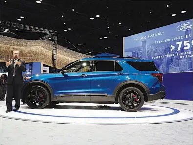  ?? AP/NAM Y. HUH ?? Ford Motor Co. executive Joe Hinrichs stands Thursday beside an Explorer at the Chicago Auto Show. Executives are positionin­g the company to produce more SUVs.