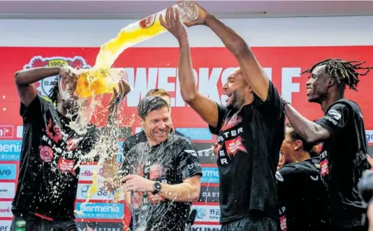  ?? MARTIN MEISSNER (AP/LAPRESSE) ?? Los jugadores del Leverkusen bañan a Xabi Alonso en cerveza tras el triunfo.