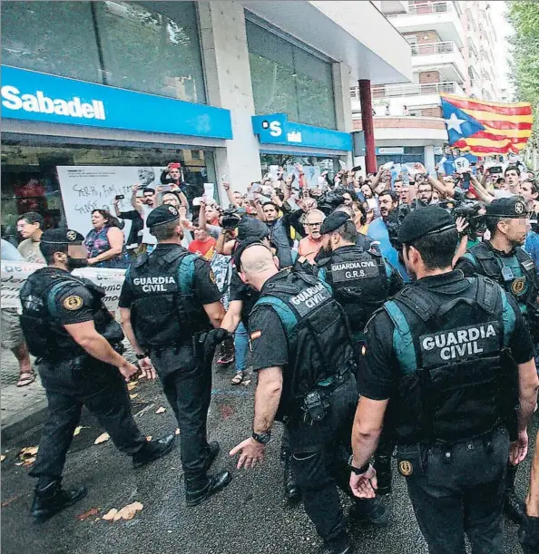  ??  ?? La Guardia Civil, ayer, en la ciudad de Valls donde registró la sede de un semanario local, ante la protesta de muchos soberanist­as