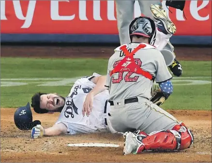  ?? Mark J. Terrill Associated Press ?? IT WAS QUITE a trip around the bases for Rich Hill during the fourth inning. He reached on a bunt single, advanced to second and third on wild pitches, then was tagged out at the plate by Pirates catcher Elias Diaz as he tried to score on a f ly ball by Max Muncy.