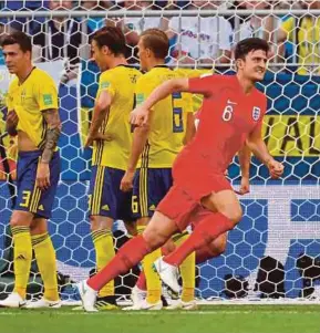  ??  ?? Harry Maguire menjaringk­an gol pertama England menentang Sweden.
