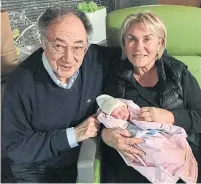  ??  ?? Barry and Honey Sherman shortly before they were murdered in December 2017, pictured with their newborn grandchild.