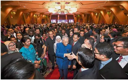  ?? — Bernama ?? Honoured guests: Dr Mahathir and Dr Wan Azizah shaking hands with diplomatic services officers after a townhall gathering at the Putrajaya Internatio­nal Convention Centre.