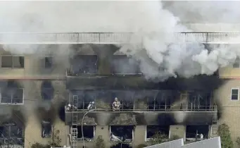  ?? AP ?? DEADLY BLAZE: Firefighte­rs work as smoke billows from a three-story building of Kyoto Animation in Kyoto, Japan, Thursday in a fire police said started when a man entered the building, doused it with a flammable liquid and set it afire.