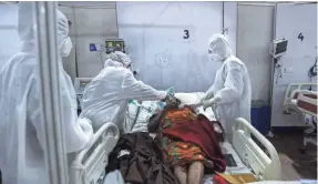  ?? RAFIQ MAQBOOL/AP ?? Health workers give water on May 6 to a patient at the BKC jumbo field hospital, one of the largest COVID-19 facilities in Mumbai.