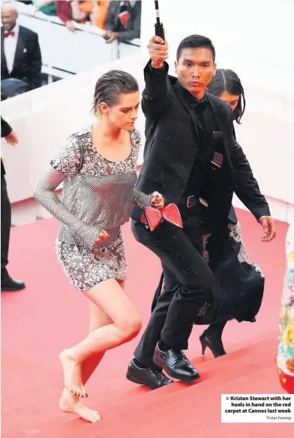  ?? Tristan Fewings ?? > Kristen Stewart with her heels in hand on the red carpet at Cannes last week