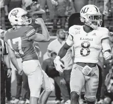  ?? Chuck Burton / Associated Press ?? Texas' Cameron Dicker, left, celebrates his winning field goal as time expires as Kansas' Kwamie Lassiter II watches.