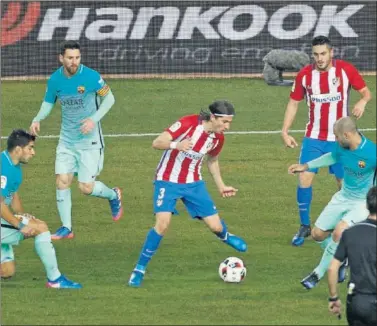  ??  ?? INTENSO. Filipe intenta progresar entre Mascherano, Suárez y Messi con Koke a la expectativ­a.