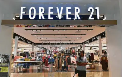  ?? Frederic J. Brown / AFP/Getty Images ?? A shopper exits a Forever 21 store at a shopping mall in Montebello, Calif., on Monday, a day after the fashion retailer filed for Chapter 11 bankruptcy protection. Forever 21 plans to close up to 178 of its stores nationwide.