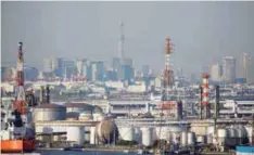  ?? REUTERSPIX ?? Chimneys of an industrial complex and Tokyo's skyline are seen from an observator­y deck at an industrial port in Kawasaki, Japan.