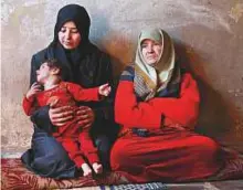  ?? AFP ?? A woman holds her one-year-old malnourish­ed son Qamar in her house in the besieged rebel-held eastern Ghouta area near Damascus.