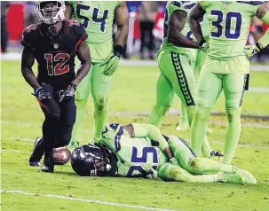  ?? RICK SCUTERI/ASSOCIATED PRESS ?? Standout Seattle cornerback Richard Sherman (25) lies on the turf after tearing his Achilles tendon making a tackle on Arizona receiver John Brown (12) on Thursday night.