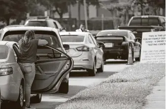  ?? Steve Gonzales / Staff photograph­er ?? A woman looks to see how close she is to My Family Doctor on Hillcroft, which was offering free COVID-19 testing Thursday. The long line stretched from the clinic onto the U.S. 59 offramp.