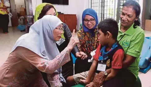  ??  ?? DR Wan Azizah diiringi Elahe (dua dari kiri) bermesra dengan pelajar di Taman U Thant, Ampang, semalam.