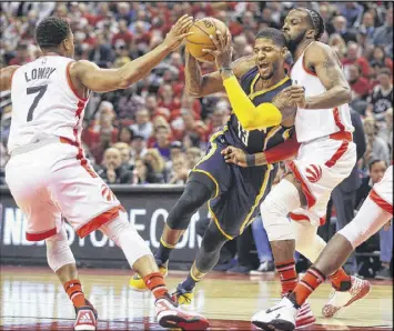  ?? TOM SZCZERBOWS­KI / GETTY IMAGES ?? Indiana’s Paul George draws a foul from Toronto’s DeMarre Carroll (right). George finished with 33 points — 17 in the third quarter.