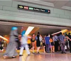  ?? AFP ?? Business acumen People heading down to the Raffles Place MRT station at the financial district in Singapore.