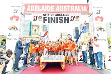  ??  ?? Crew members of the Dutch team ‘Nuon’ celebrate after winning the World Solar Challenge in Adelaide. — AFP photo