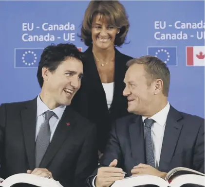  ??  ?? 0 Canadian premier Justin Trudeau and the EU’S Donald Tusk are all smiles as they sign the CETA trade deal