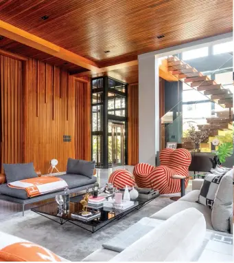  ?? ?? This page, from left: A feature wall clad in narra slats stands out in the living room; The modern show kitchen comes with laminated modular cabinetry