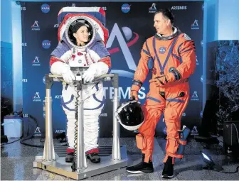  ?? Kevin Wolf / Associated Press ?? Kristine Davis wears the prototype for exploring the moon’s South Pole, known as the Exploratio­n Extravehic­ular Mobility Unit, and Dustin Gohmert wears the Orion Crew Survival Suit.