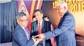  ??  ?? Ceylinco Life Administra­tion Senior Assistant Manager Sherman de Silva receives a Long Service Award for more than 30 years of service from the company’s Managing Director and CEO R. Renganatha­n