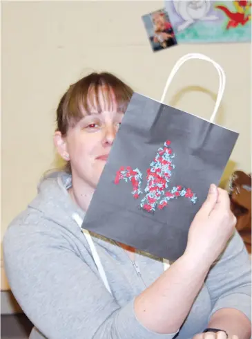  ??  ?? Rover Alison Roberts with on of her designs on the care package bags.