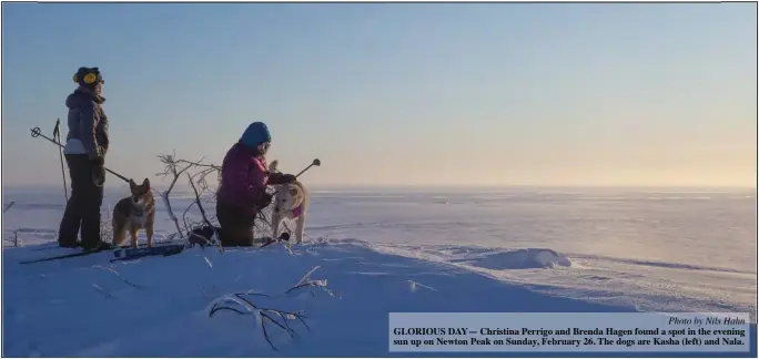  ?? Photo by Nils Hahn ?? GLORIOUS DAY— Christina Perrigo and Brenda Hagen found a spot in the evening sun up on Newton Peak on Sunday, February 26. The dogs are Kasha (left) and Nala.