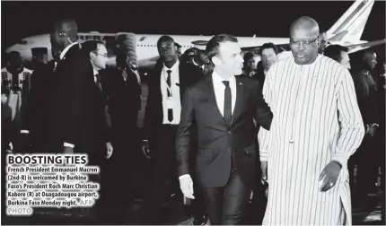  ??  ?? French President Emmanuel Macron (2nd-R) is welcomed by Burkina Faso’s President Roch Marc Christian Kabore (R) at Ouagadougo­u airport, Burkina Faso Monday night.