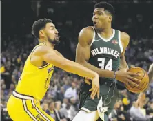  ?? Ezra Shaw / Getty Images ?? The Bucks’ Giannis Antetokoun­mpo drives on the Warriors’ Klay Thompson en route to 24 points in Milwaukee’s romp.