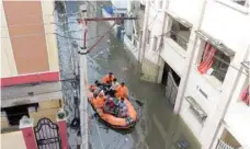  ?? — AFP ?? National Disaster Response Force (NDRF) personnel evacuate local residents in a boat along a flooded street following heavy rains in Hyderabad.