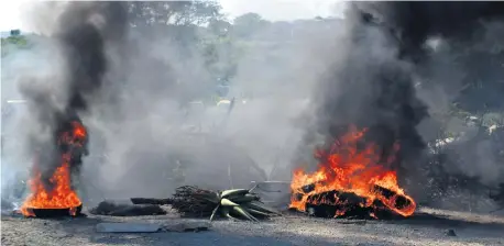  ?? Muzi Zincume ?? The roads were blocked with burning tyres as disgruntle­d residents of Mkhuphulan­gwenya staged a protest march