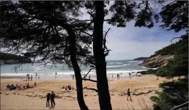  ?? (AP/Robert F. Bukaty) ?? Beachgoers enjoy Sand Beach on June 11 in Acadia National Park near Bar Harbor, Maine. The park will not have lifeguards on duty this summer due to worker and housing shortages.