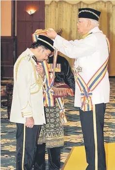  ??  ?? Mohd Khalil confers the Darjah Cemerlang Melaka (DCSM) award on Mustafar during the ceremony. — Bernama photo