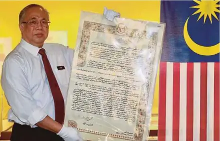  ?? PIC BY FATHIL ASRI. ?? National Archives of Malaysia director-general Datuk Azemi Abdul Aziz showing the agreement in Kuala Lumpur recently on the formation of Malaysia which was written in Jawi.