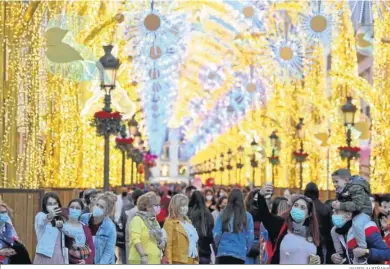  ?? JAVIER ALBIÑANA ?? Un grupo de personas pasean por el centro de Málaga, durante la última Navidad.