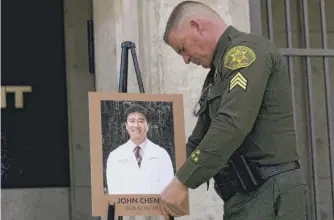  ?? JAE C. HONG/AP ?? Orange County Sheriff’s Sgt. Scott Steinle displays a photo of Dr. John Cheng on Monday.