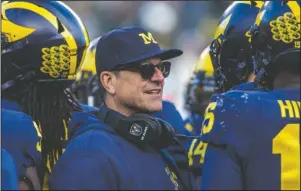  ?? The Associated Press ?? STARTING SEASON SIX: Michigan head coach Jim Harbaugh huddles with his players on the field during a time out in the fourth quarter of a Nov. 16, 2019, game against Michigan State in Ann Arbor, Mich. Harbaugh enters his sixth season as Michigan’s coach with just two years left on his contract, adding another layer of interest in the 18th-ranked Wolverines as they kick off the season this week at No. 21 Minnesota.