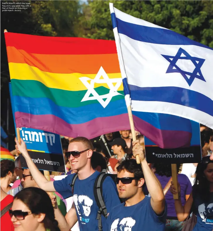  ?? (Reuters) ?? PARTICIPAN­TS HOLD the Israel flag and a gay pride flag with a Star of David on it during a pride march.