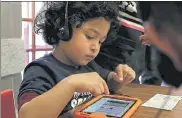  ?? FILE PHOTO / SENTINEL & ENTERPRISE ?? Preschool student Christophe­r Gonzalez-Hernandez, 4, plays with the Footsteps2­Brilliance app on a tablet at the Fitchburg Flourishes Early Learning Literacy summit at Fitchburg High School in May 2017.