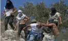  ?? Photograph: Jaafar Ashtiyeh/AFP/Get- ?? Masked Israeli settlers attack a Palestinia­n olive farmer in a West Bank village.