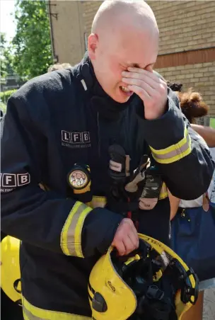  ??  ?? Overwhelme­d: A fireman sobs during the minute’s silence yesterday