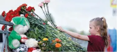  ?? Associated Press ?? A girl lays flowers near a school after a shooting in Kazan on Tuesday.