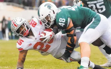  ?? KIRTHMON F. DOZIER/TNS ?? Michigan State's Kenny Willekes (48) tackles Ohio State's Mike Weber Jr. during first-half action Saturday at Spartan Stadium, in East Lansing, Mich. Ohio State won, 26-6.