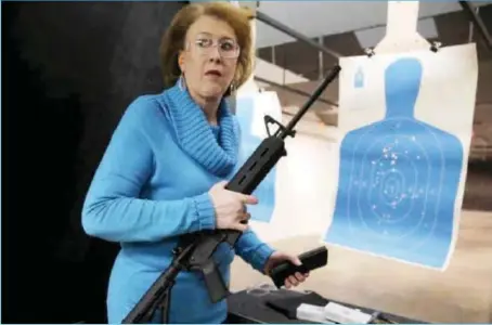  ??  ?? Janet Huckabee, wife of Mike Huckabee, holding an AR-15 assault rifle at a gun shop during a campaign event in Hiawatha, Iowa…weekend