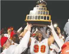  ?? JACQUES BOISSINOT / THE CANADIAN PRESS FILES ?? University of Calgary Dinos' J-Min Pelley raises the U Sports Vanier Cup with teammates in Quebec City after winning the 2019 university football championsh­ip against the University of Montreal Carabins.