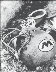  ?? Associated Press ?? Tragedy: In this Oct. 3, 1970, file photo, a charred Wichita State University football helmet is shown amid the wreckage of a plane that crashed in Silver Plume, Colo. Six weeks later, on Nov. 14, 1970, a plane carrying members of the Marshall football team crashed. As fate would have it, Marshall's first trip to the NCAA Tournament in 31 years means a date with Wichita State on Friday in San Diego.